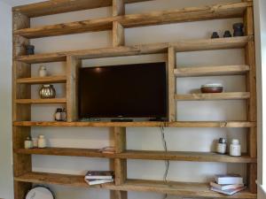 a wooden shelf with a tv on a wall at Loyal Cerise in Cawood