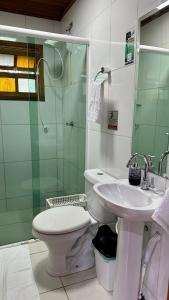 a bathroom with a toilet and a sink and a shower at Casinha na Ilha do Mel - Pr in Ilha do Mel