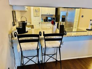 a kitchen with two bar stools at a counter at Eclectic 3 bedroom townhouse with back terrace in Tallahassee