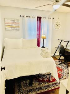 ein Schlafzimmer mit einem großen weißen Bett und einem Fenster in der Unterkunft Eclectic 3 bedroom townhouse with back terrace in Tallahassee