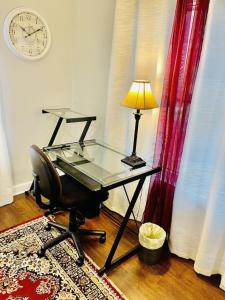 a glass desk with a lamp and a chair at Eclectic 3 bedroom townhouse with back terrace in Tallahassee