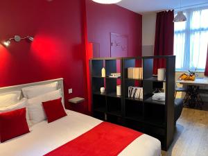 - une chambre rouge avec un lit avec un mur rouge dans l'établissement PlacesAppart, à Arras