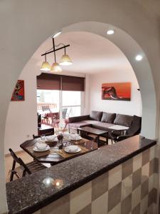 un soggiorno con tavolo e divano di 2BDR Sunny apartment with pool and private parking in Benalmádena a Benalmádena
