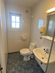 a white bathroom with a toilet and a sink at Haraldshaugen Camping in Haugesund