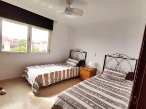 a bedroom with two beds and a window at 2BDR Sunny apartment with pool and private parking in Benalmádena in Benalmádena