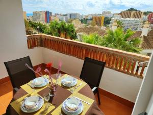 a dining room with a table and chairs and a balcony at 2BDR Sunny apartment with pool and private parking in Benalmádena in Benalmádena