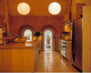 a kitchen with a brick wall and a refrigerator at Mountain Church in Capel-Curig