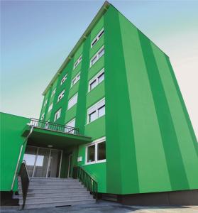 a green building with stairs in front of it at Hotel Olive Inn in Aschaffenburg