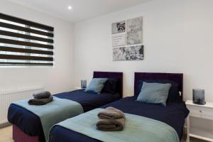 a bedroom with two beds with towels on them at Star London Station Road 3-Bed Oasis with Garden in The Hyde