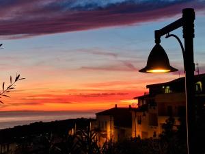 a street light with a sunset in the background at Residence Pala Stiddata with panoramic swimming pool in Trinità d'Agultu e Vignola