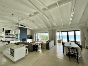 a kitchen and living room with a view of the ocean at Dageraad in Plettenberg Bay