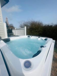 uma banheira de hidromassagem sentada num quintal com água azul em Yorkshire Lodge with Hot Tub em York