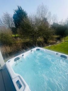 uma banheira de hidromassagem no quintal de uma casa em Yorkshire Lodge with Hot Tub em York