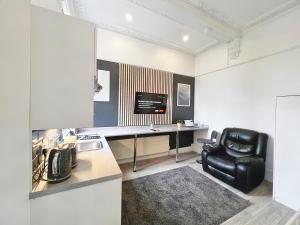 a kitchen with a desk and a black leather chair at Erin Court Mansions - Suite 13 in Croydon