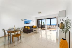 uma sala de estar com um sofá e uma mesa em Home2Book Charming Seashell Apartment Beachview em Playa Honda
