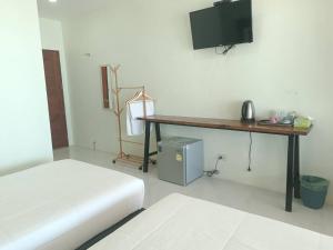 - une chambre avec un bureau et une télévision murale dans l'établissement Ma Lay Resort, à Ban Pheng Krong