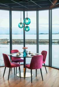 Thon Hotel Ålesund في أوليسوند: غرفة طعام مع طاولة وكراسي حمراء