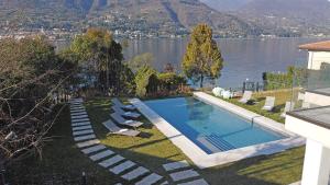 una piscina con sillas y vistas al lago en Villa Bianca directly on the lake modern amazing, en San Felice del Benaco