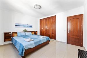 1 dormitorio con 1 cama y reloj en la pared en Home2Book Charming Seashell Apartment Beachview en Playa Honda