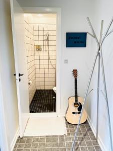 a shower with a guitar in a bathroom at Randers residence Sankt Andreas - 2 room apartment in Randers