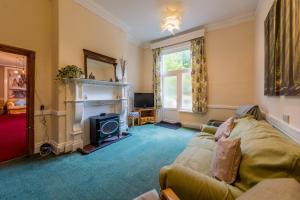 uma sala de estar com um sofá e uma lareira em Private 7 bed wing of former farmhouse, edge of Exmoor, sleeps 16 em East Anstey