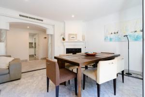 a dining room with a wooden table and chairs at White Pearl Beach Elviria in Marbella