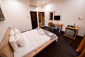 a bedroom with a large bed and a desk at Royal Regantris Villa Karang in Gili Air