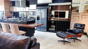 a kitchen with leather chairs and a table and a counter at Casa Luxo Jacuzzi aquecida prox Cataratas e Aerpt in Foz do Iguaçu