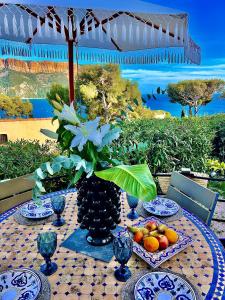 una mesa con platos de fruta y un jarrón de flores en Astoria Villa maison d hôtes Appartement vue mer avec piscine, en Cassis