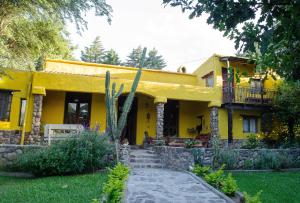 a yellow house with a porch and a balcony at Rincon del Valle in San Salvador de Jujuy