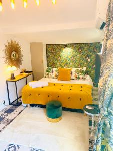 1 dormitorio con cama amarilla y pared amarilla en Astoria Villa maison d hôtes Appartement vue mer avec piscine, en Cassis