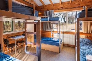 een kamer met een stapelbed en een tafel en stoelen bij Stayokay Hostel Gorssel - Deventer in Gorssel