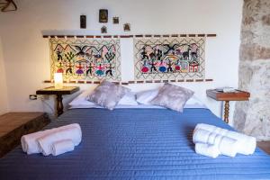 Un dormitorio con una cama azul con toallas. en Villa Cefalu private pool, en SantʼAmbrogio