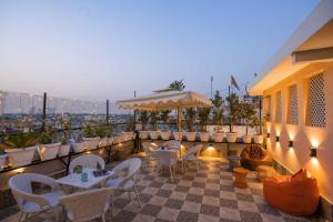 a patio with tables and chairs and an umbrella at Zostel Delhi in New Delhi