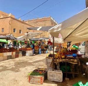 an outdoor market with fruits and vegetables on display at Hike and Chill Homestay in Tinerhir