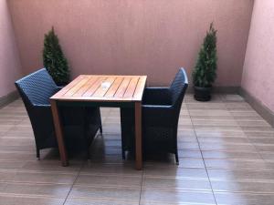 ein Holztisch mit zwei Stühlen und zwei Pflanzen in der Unterkunft Hotel Rivoli in Bukarest