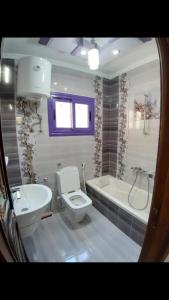 a bathroom with a toilet and a sink and a tub at زهرة مطروح للشقق الفندقية in Marsa Matruh