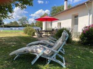 dos sillas de césped y un paraguas en un patio en Attractive holiday home in Valigny with private pool, en Valigny