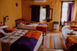 a bedroom with three beds in a room with a window at Rincon del Valle in San Salvador de Jujuy