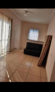 een woonkamer met een bank en een raam bij Beachouse Marissol Morada da Praia in Bertioga