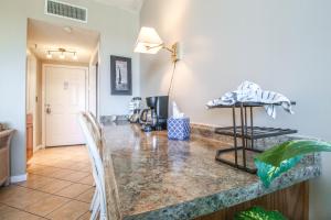 a kitchen with a marble counter top with chairs at Pirates Bay A402 in Fort Walton Beach