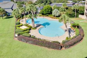 an overhead view of a swimming pool with palm trees and grass at Pirates Bay A402 in Fort Walton Beach