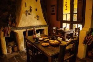 een eetkamer met een tafel en een open haard bij Rincon del Valle in San Salvador de Jujuy