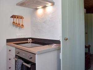 a kitchen with a sink and a stove at Gamekeepers Cottage in Newchapel