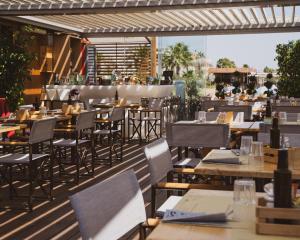 a restaurant with tables and chairs on a patio at Le Palmette Suites in Cagliari