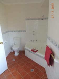 a bathroom with a white tub and a toilet at Nelsons of Bridgetown in Bridgetown