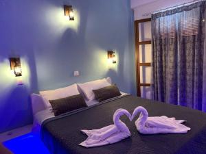 una camera da letto con 2 asciugamani cigni su un letto di Fisherman's Lodge a Karpathos