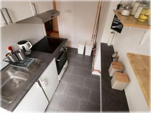a small kitchen with a sink and a stove at Altbaucharme! 2Zimmer, zentral und 24h Check-in in Kiel