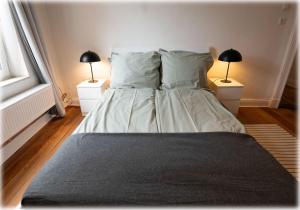 1 dormitorio con 1 cama con almohadas y 2 lámparas en Altbaucharme! 2Zimmer, zentral und 24h Check-in, en Kiel
