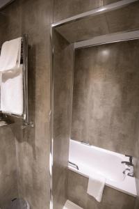 a bathroom with a shower and a bath tub at Healds Hall Hotel in Cleckheaton